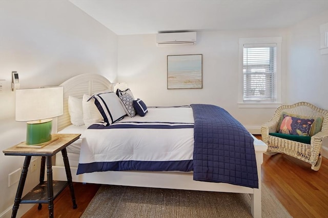 bedroom featuring hardwood / wood-style floors and a wall mounted AC