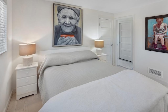 bedroom featuring multiple windows and light hardwood / wood-style floors