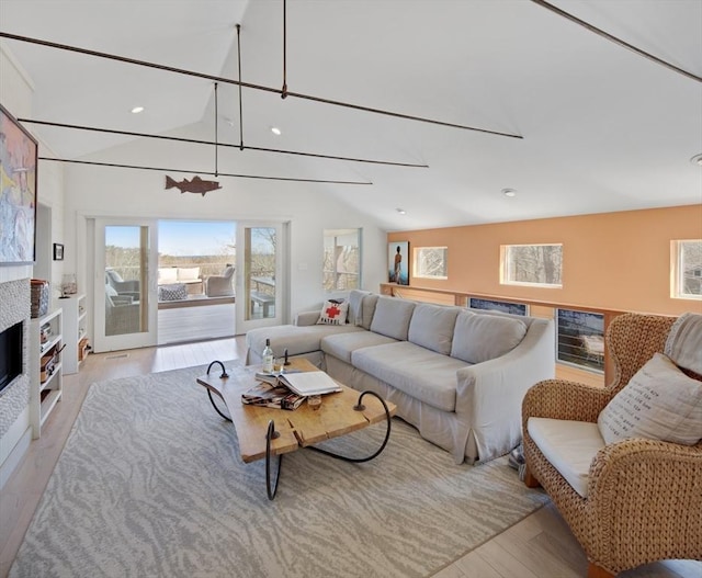 living room featuring vaulted ceiling and light hardwood / wood-style flooring