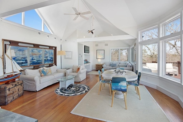 living room featuring hardwood / wood-style flooring, ceiling fan, and high vaulted ceiling