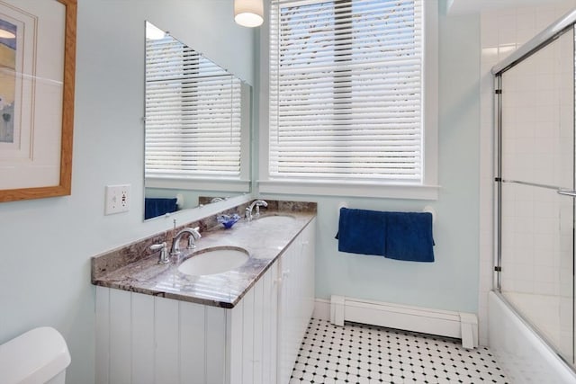 full bathroom featuring enclosed tub / shower combo, a baseboard radiator, vanity, and toilet