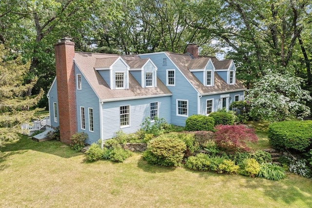 1074 Concord Rd, Sudbury, MA 01776 - rear view of property featuring a chimney, a yard, view of scattered trees, and roof with shingles