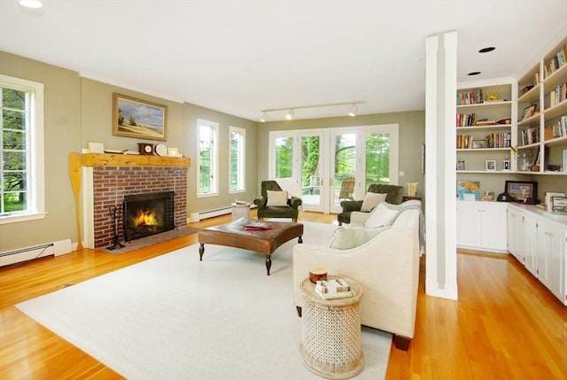 1074 Concord Rd, Sudbury, MA 01776 - living area with a baseboard radiator, light wood-style flooring, and healthy amount of natural light