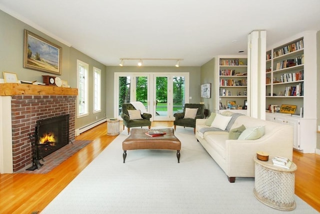1074 Concord Rd, Sudbury, MA 01776 - living area featuring a baseboard radiator, wood finished floors, and a brick fireplace