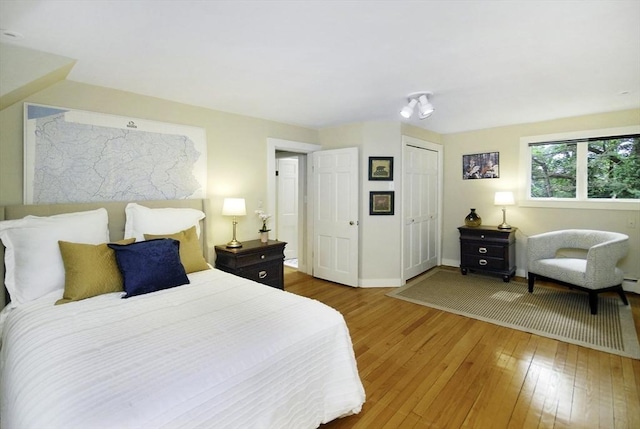 1074 Concord Rd, Sudbury, MA 01776 - bedroom with wood-type flooring, baseboards, a closet, and a baseboard heating unit