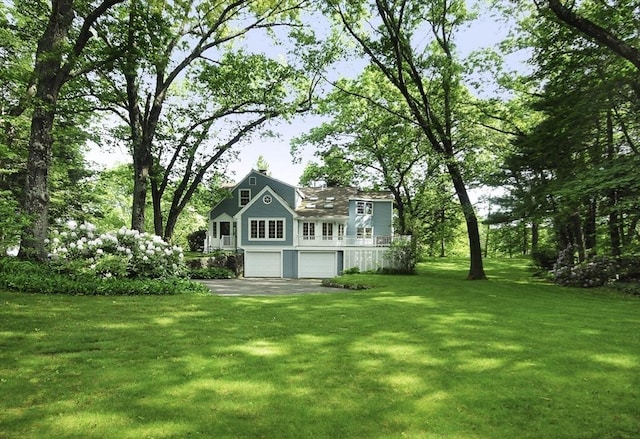 1074 Concord Rd, Sudbury, MA 01776 - rear view of house with a garage, a lawn, and asphalt driveway