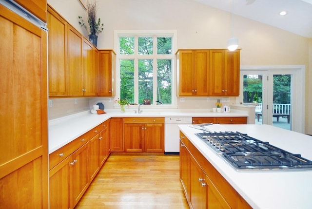 1074 Concord Rd, Sudbury, MA 01776 - kitchen featuring white dishwasher, stainless steel gas stovetop, light wood-type flooring, lofted ceiling, and light countertops