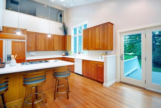 1074 Concord Rd, Sudbury, MA 01776 - kitchen featuring white appliances, a high ceiling, brown cabinets, and a breakfast bar area