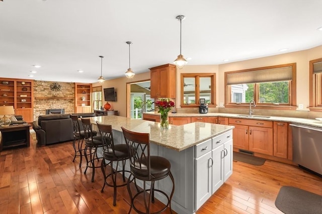16 Blueberry Way, Webster, MA 01570 - kitchen featuring dishwasher, light wood-style floors, light stone countertops, a fireplace, and a center island