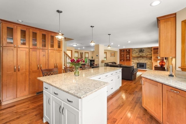 16 Blueberry Way, Webster, MA 01570 - kitchen featuring a kitchen island, light wood-type flooring, recessed lighting, a stone fireplace, and open floor plan