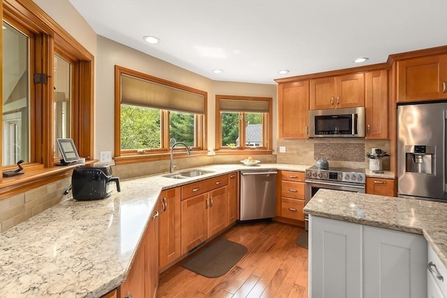 16 Blueberry Way, Webster, MA 01570 - kitchen with appliances with stainless steel finishes, light wood-type flooring, brown cabinets, backsplash, and recessed lighting