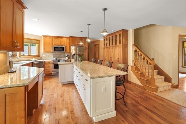 16 Blueberry Way, Webster, MA 01570 - kitchen with appliances with stainless steel finishes, light wood-type flooring, a center island, tasteful backsplash, and recessed lighting