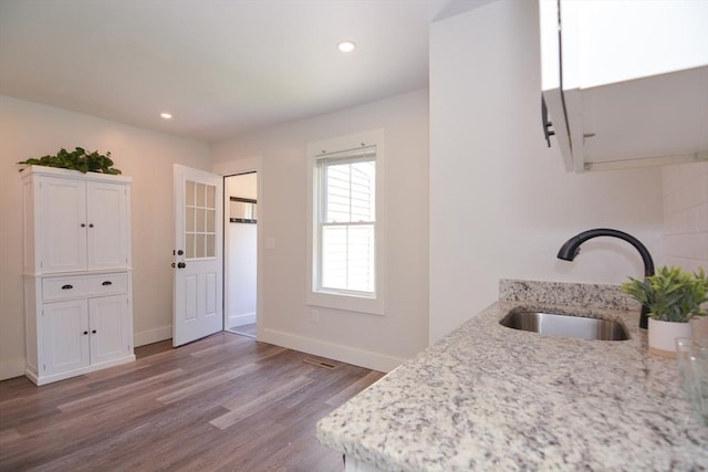 22 Chester Unit 22, Amesbury, MA 01913 - kitchen with a sink, wood finished floors, light stone counters, recessed lighting, and white cabinets