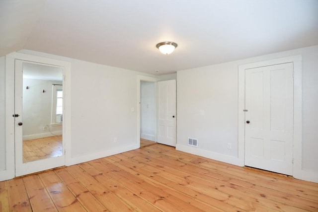 22 Chester Unit 22, Amesbury, MA 01913 - unfurnished bedroom with light wood finished floors, baseboards, ensuite bath, and vaulted ceiling