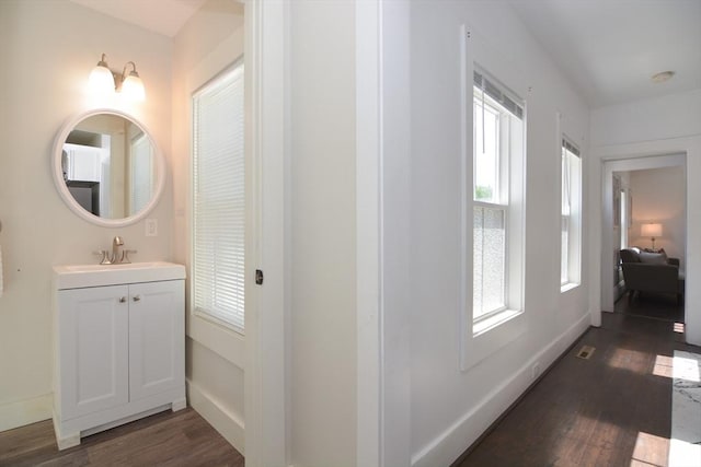 22 Chester Unit 22, Amesbury, MA 01913 - hallway featuring dark wood-style flooring, a sink, plenty of natural light, and baseboards