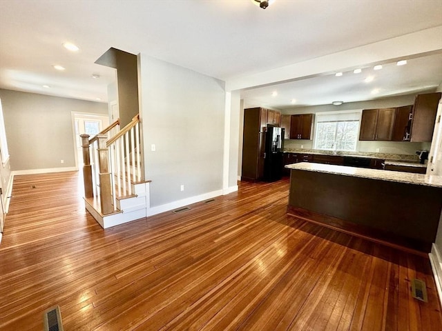 kitchen with visible vents, baseboards, dark wood-style flooring, and freestanding refrigerator