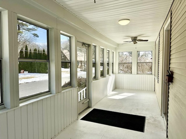 unfurnished sunroom with a ceiling fan and a wealth of natural light