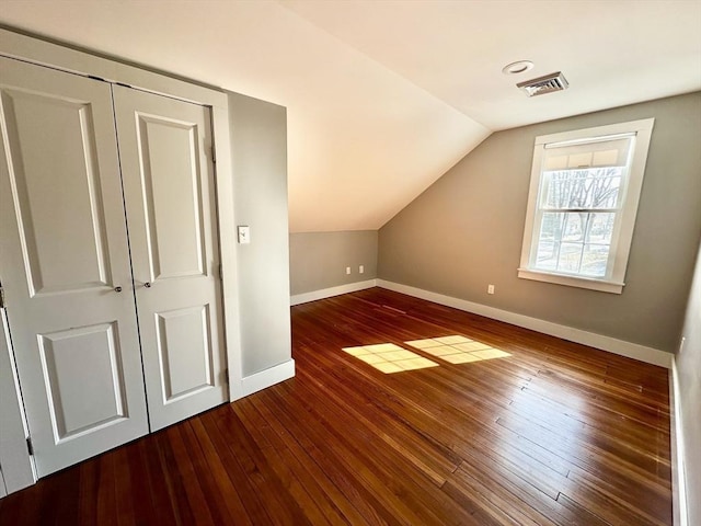 bonus room with vaulted ceiling, hardwood / wood-style floors, visible vents, and baseboards