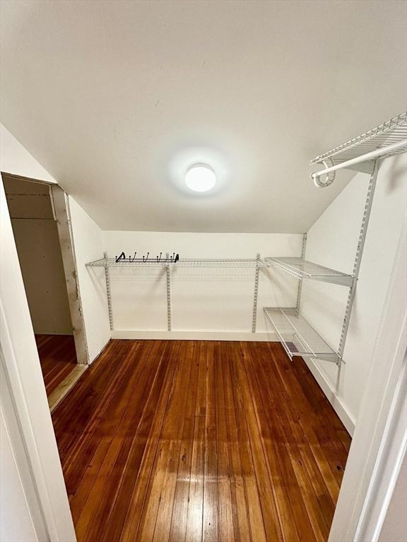 walk in closet featuring dark wood-style floors and vaulted ceiling