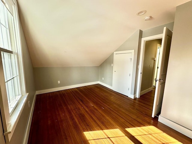 bonus room featuring lofted ceiling, hardwood / wood-style flooring, and baseboards