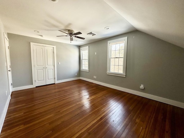 interior space featuring visible vents, baseboards, ceiling fan, hardwood / wood-style floors, and vaulted ceiling