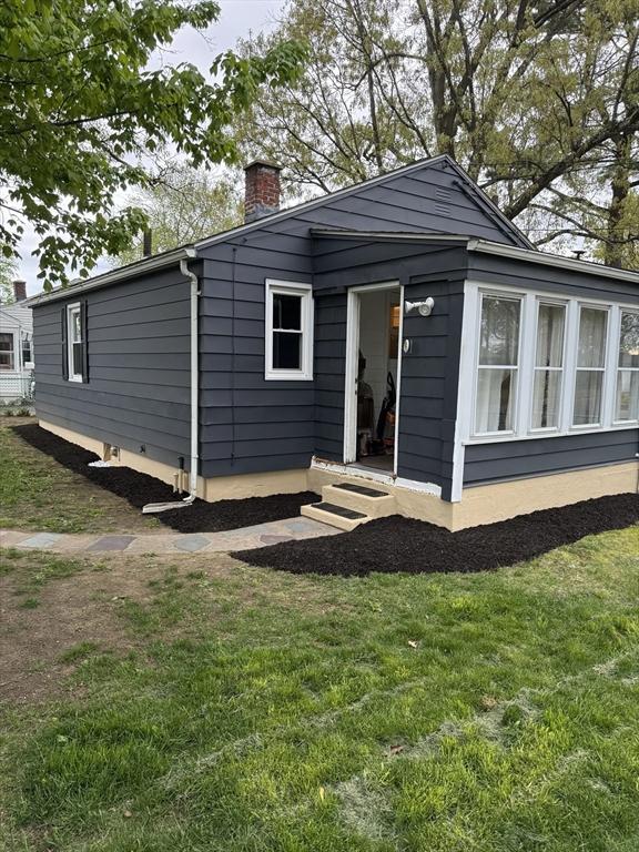 rear view of house featuring a lawn