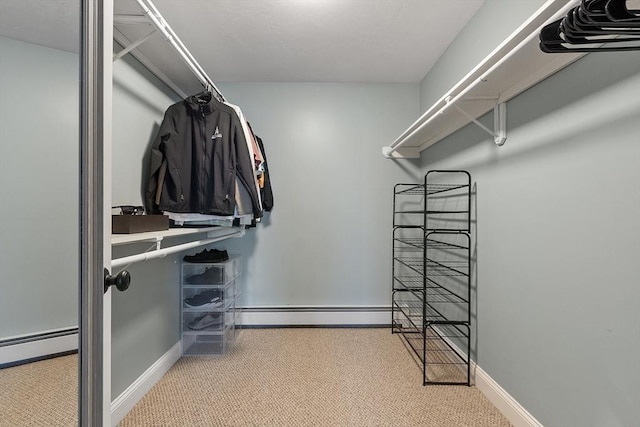 walk in closet with baseboard heating and light colored carpet