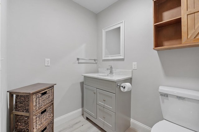 bathroom featuring toilet, vanity, and hardwood / wood-style floors