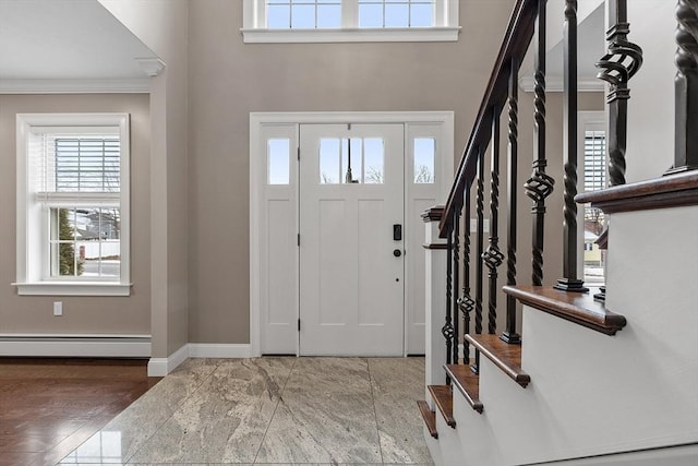 entryway featuring a baseboard heating unit and ornamental molding