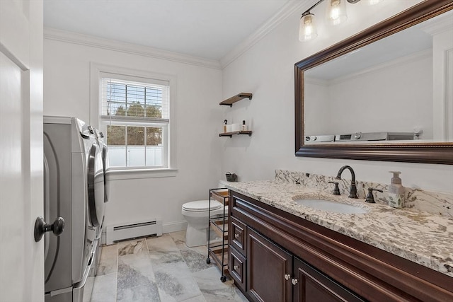 bathroom with baseboard heating, vanity, washing machine and clothes dryer, toilet, and crown molding