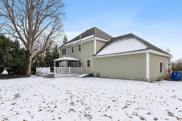 snow covered rear of property with a gazebo