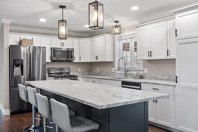 kitchen with decorative light fixtures, sink, white cabinetry, and appliances with stainless steel finishes