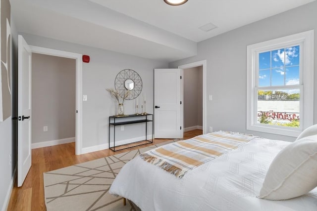 bedroom with wood finished floors and baseboards