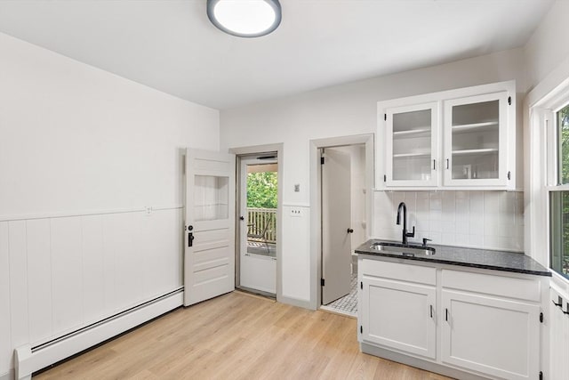 31 Hunting St, Cambridge, MA 02141 - kitchen featuring a baseboard heating unit, white cabinets, backsplash, and glass insert cabinets