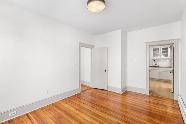 31 Hunting St, Cambridge, MA 02141 - unfurnished room with light wood finished floors and baseboard heating