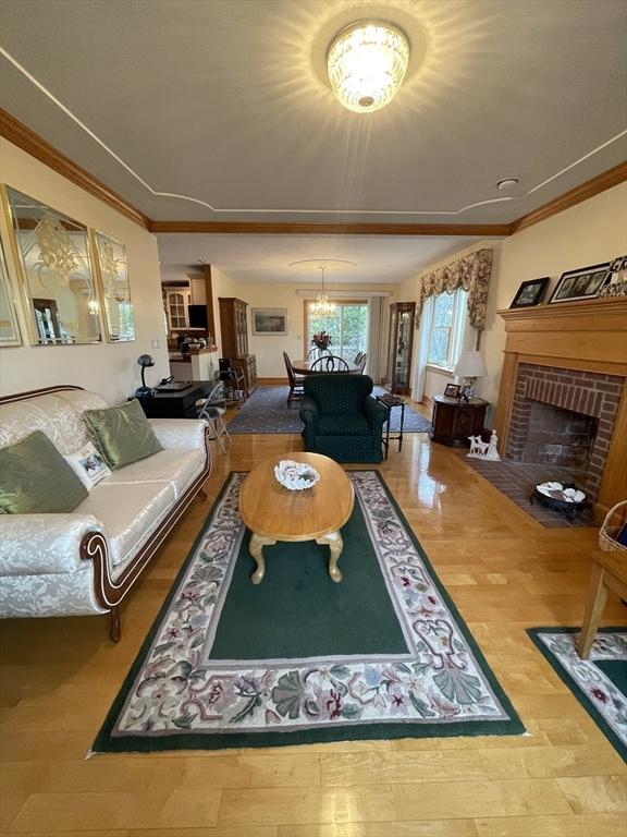 26 Feeney Rd, Norwood, MA 02062 - living area featuring a chandelier, a fireplace, wood finished floors, and crown molding