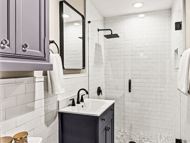 bathroom with an enclosed shower, tile walls, and vanity