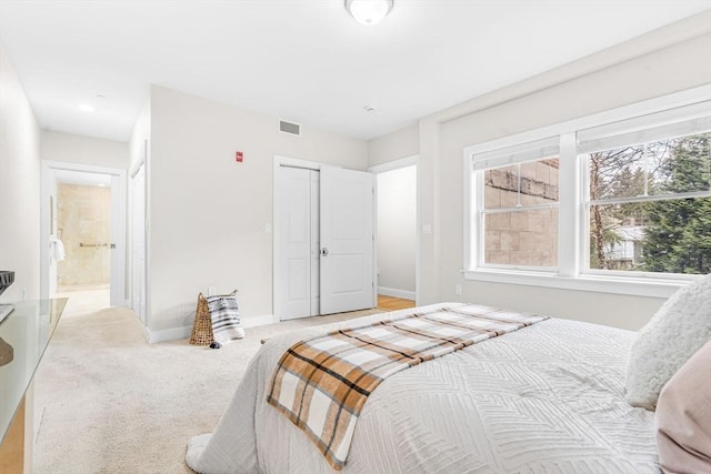 321 Hammond Pond Pkwy Unit 103, Brookline, MA 02467 - bedroom with baseboards, light carpet, a closet, and ensuite bathroom
