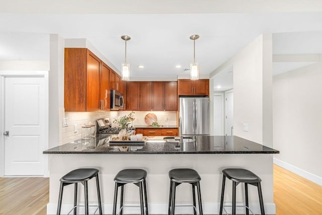 321 Hammond Pond Pkwy Unit 103, Brookline, MA 02467 - kitchen featuring appliances with stainless steel finishes, a sink, light wood-style flooring, a peninsula, and recessed lighting