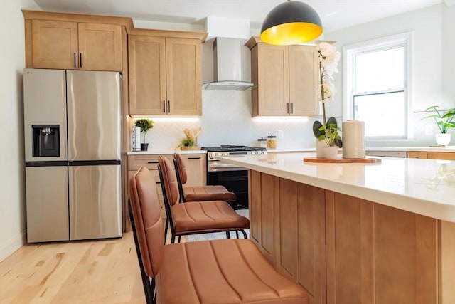 59 Dartmouth St Unit A, Somerville, MA 02145 - kitchen with appliances with stainless steel finishes, wall chimney range hood, light countertops, and light wood finished floors