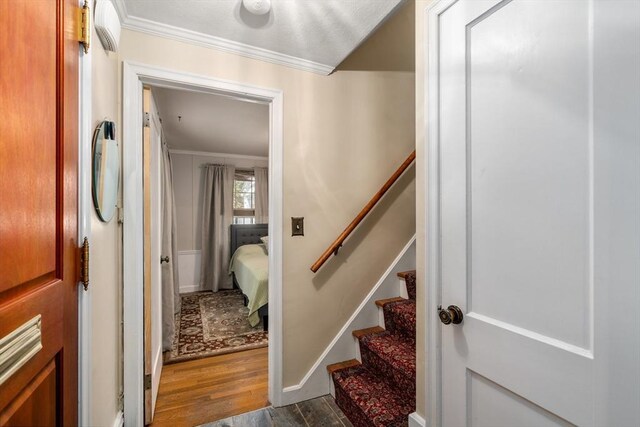 staircase with baseboards, ornamental molding, and wood finished floors