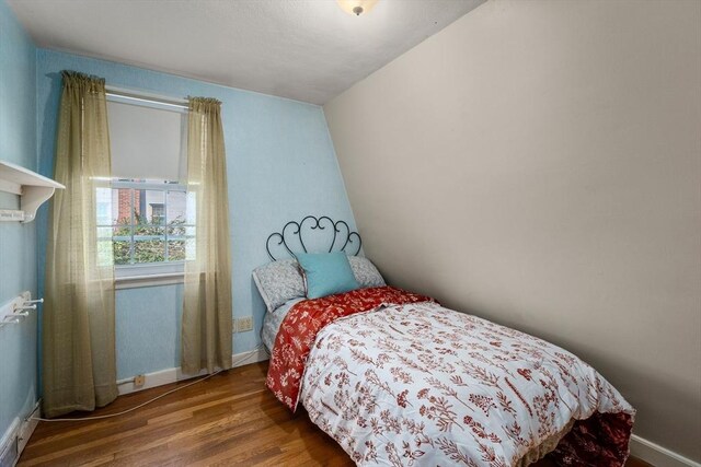 bedroom with baseboards and wood finished floors