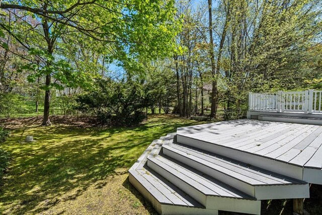 wooden deck featuring a lawn