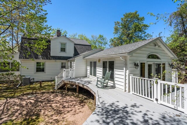 back of property featuring central AC, roof with shingles, a wooden deck, and a chimney
