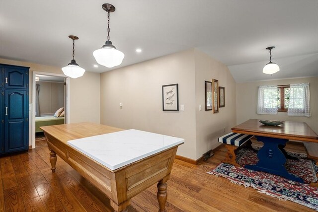 kitchen featuring dark wood-style flooring, hanging light fixtures, light countertops, blue cabinetry, and baseboards