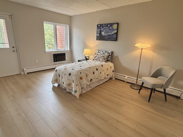 180 Green St Unit 415, Melrose, MA 02176 - bedroom with baseboard heating, wood finished floors, and a baseboard heating unit