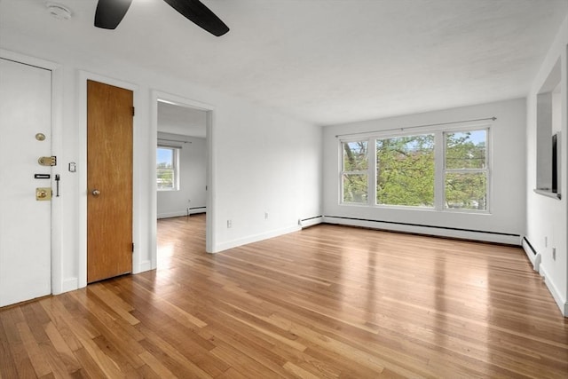 150 Main St Unit 12, Stoneham, MA 02180 - empty room featuring a ceiling fan, light wood-style flooring, baseboard heating, and a smoke detector