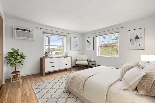 150 Main St Unit 12, Stoneham, MA 02180 - bedroom with light wood-style floors, an AC wall unit, and baseboards
