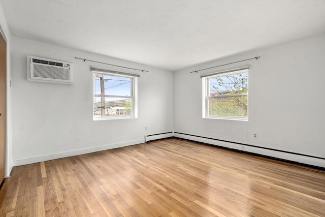 150 Main St Unit 12, Stoneham, MA 02180 - empty room with plenty of natural light, light wood-style floors, baseboard heating, and a wall mounted air conditioner