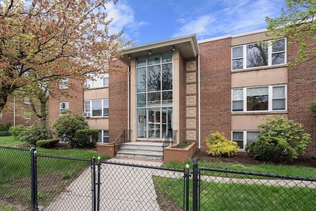 150 Main St Unit 12, Stoneham, MA 02180 - view of front facade with a fenced front yard, a gate, and brick siding